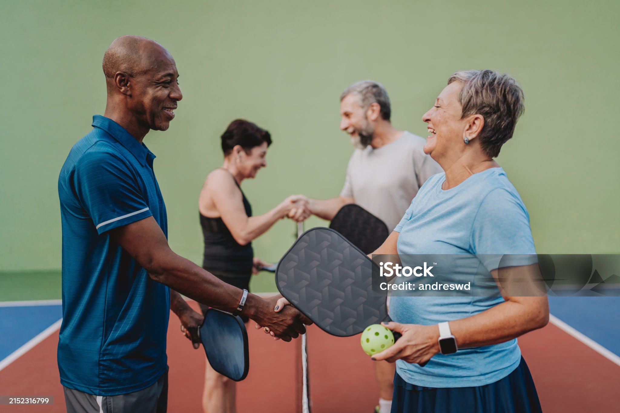 Group of people shaking hands ending pickleball game